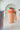Mug térmico Coca-Cola vintage color melocotón con tapa azul claro y asa de tela, mostrando el logo clásico y detalles de diseño.