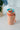 Mug térmico vintage Coca-Cola de 700ml en color melocotón con tapa azul claro, logo rojo y correa lateral, ideal para bebidas frías y calientes. Se aprecia el diseño clásico y el detalle 'EST. 1886' en el cuerpo.